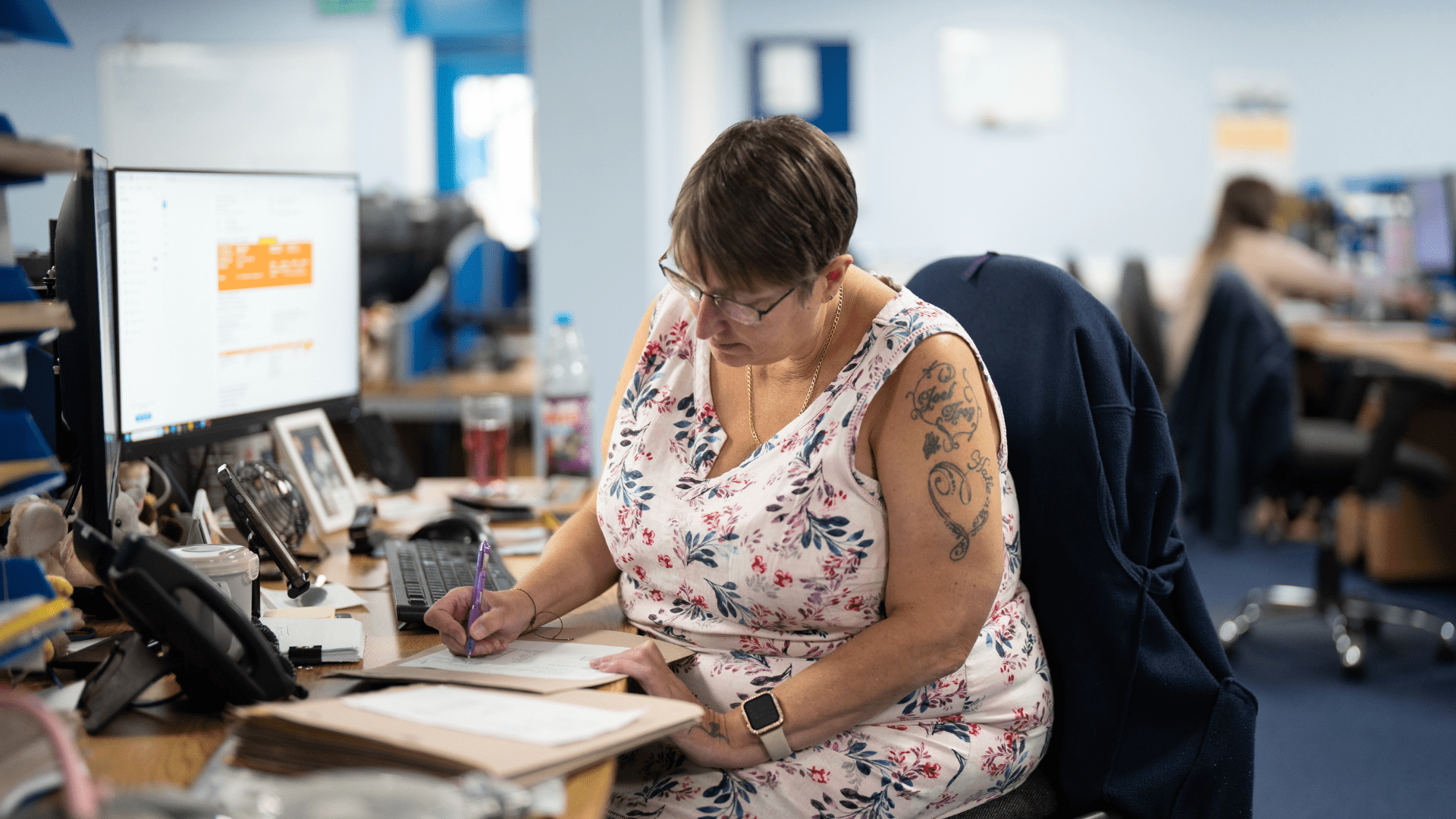 Women sat at desk writing on some paper